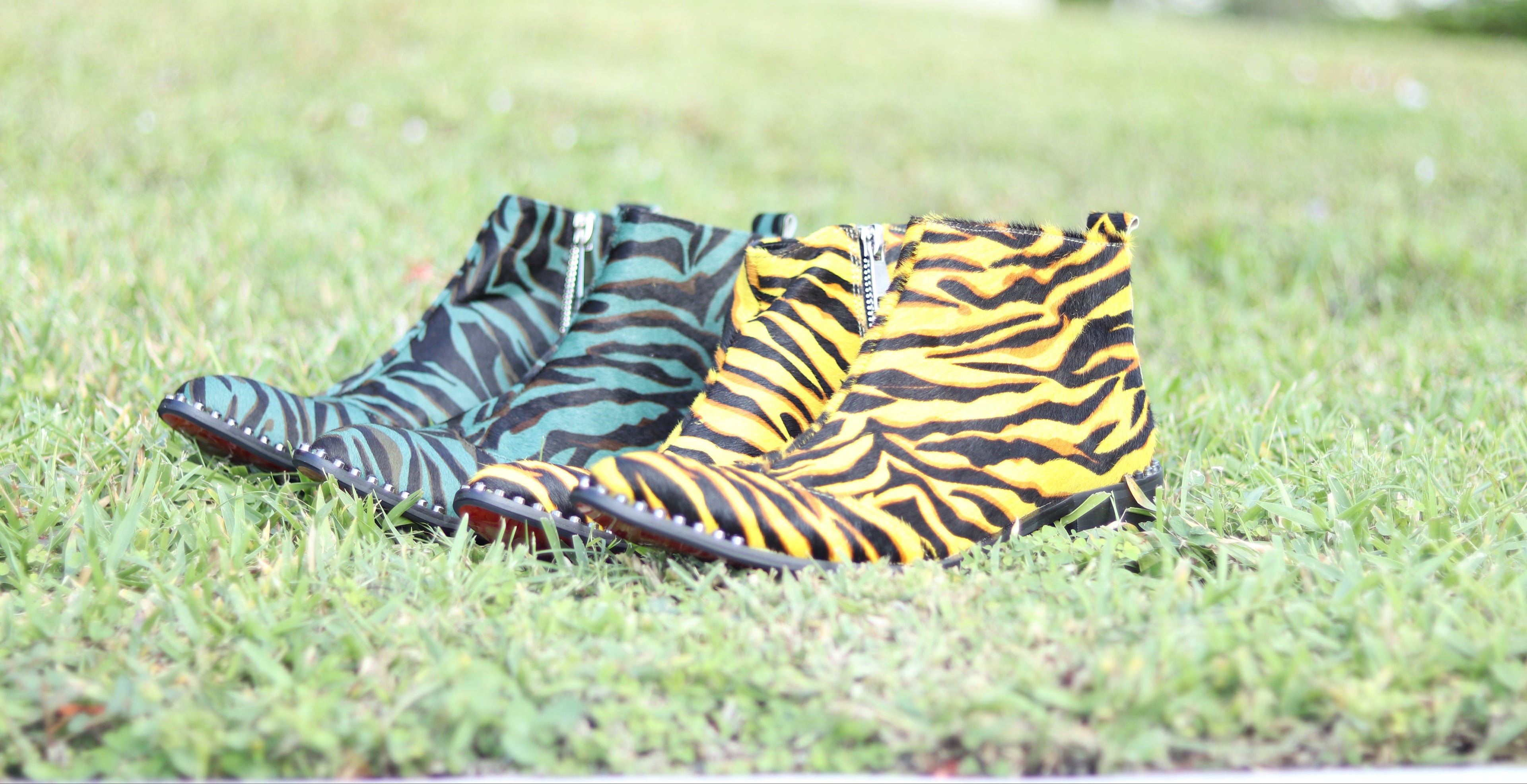 Two pairs of patterned boots on grass